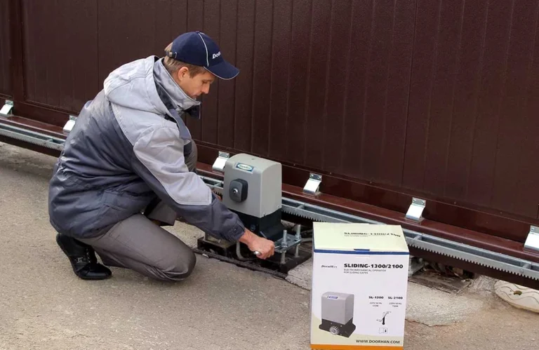 A technician inspects a broken gate while explaining typical gate repair costs in Austin for common issues.
