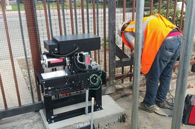 Technician servicing an automatic gate opener in Austin, Texas